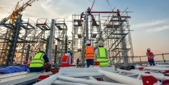 Crew in hi-vis vests on a scaffolded construction site