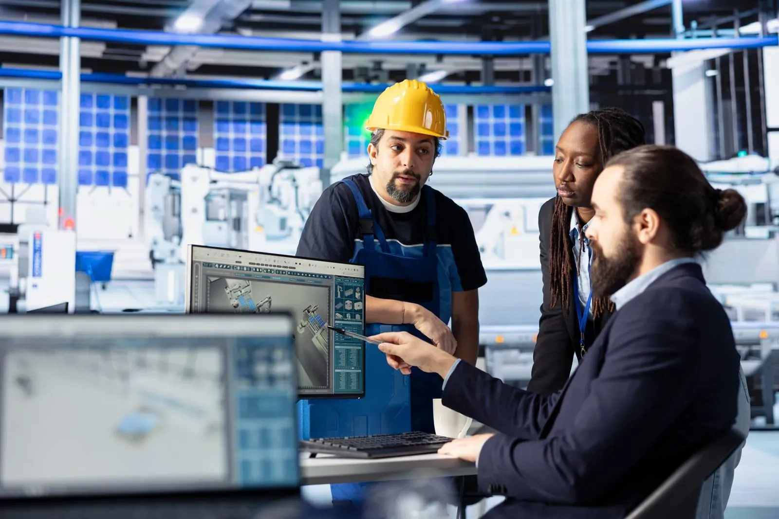 Facilities team reviewing equipment layouts in a plant control room