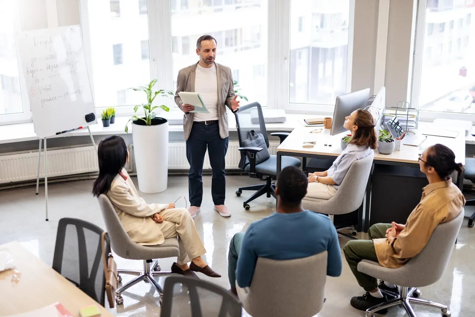 Consultant briefing a team in a bright office
